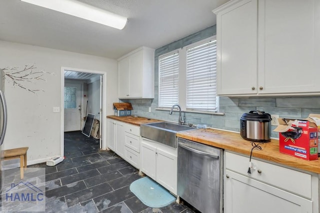 kitchen featuring white cabinetry, dishwasher, sink, wooden counters, and decorative backsplash