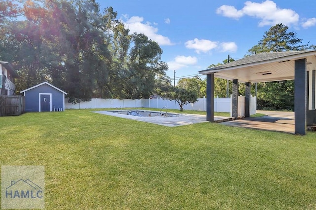 view of yard with a patio area, a fenced in pool, and a storage shed