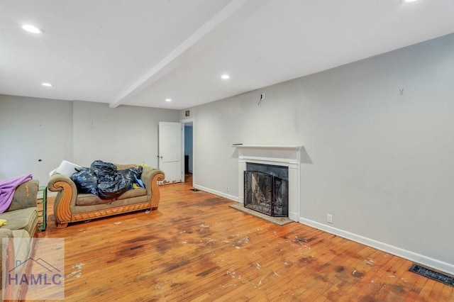 living room featuring beam ceiling and hardwood / wood-style flooring