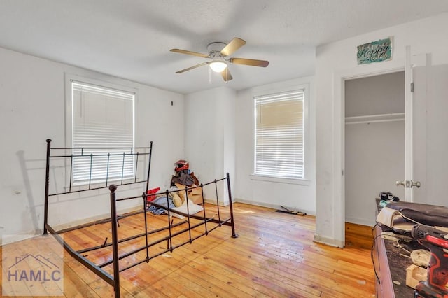 bedroom with ceiling fan, light wood-type flooring, and a closet