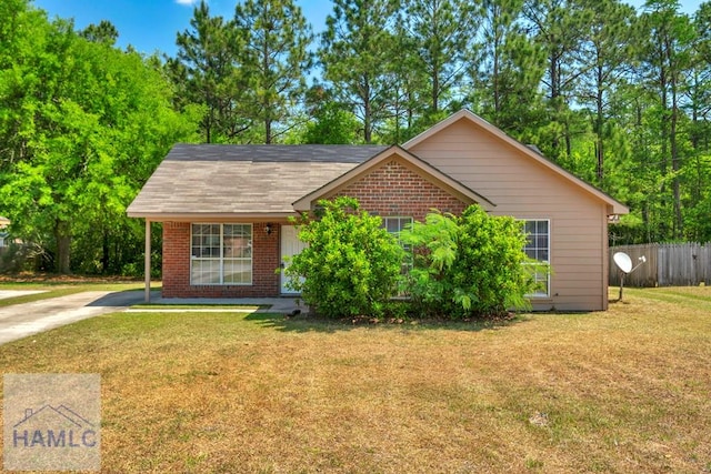 ranch-style house with brick siding, fence, a front lawn, and driveway