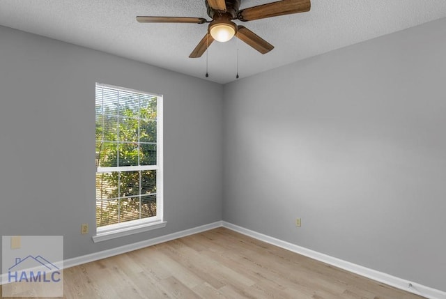 unfurnished room featuring a ceiling fan, baseboards, a textured ceiling, and light wood-type flooring