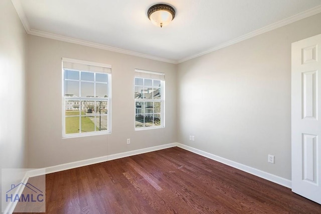 empty room featuring dark wood finished floors, crown molding, and baseboards