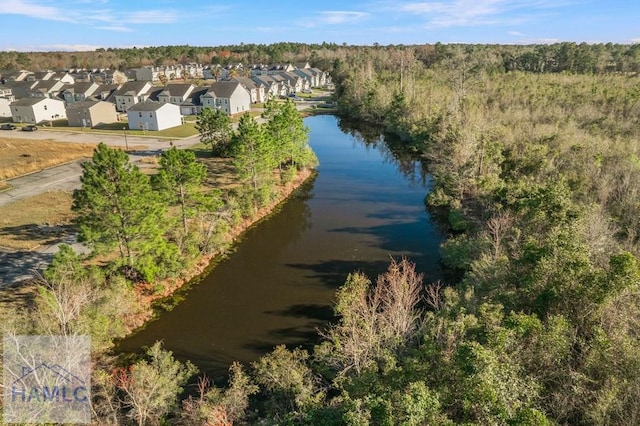 birds eye view of property with a view of trees, a residential view, and a water view