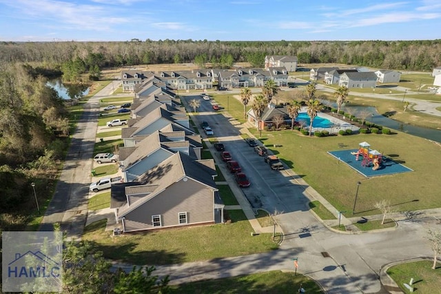 drone / aerial view featuring a wooded view and a residential view