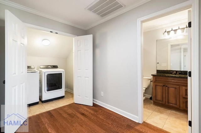 laundry room featuring visible vents, independent washer and dryer, crown molding, light tile patterned floors, and baseboards