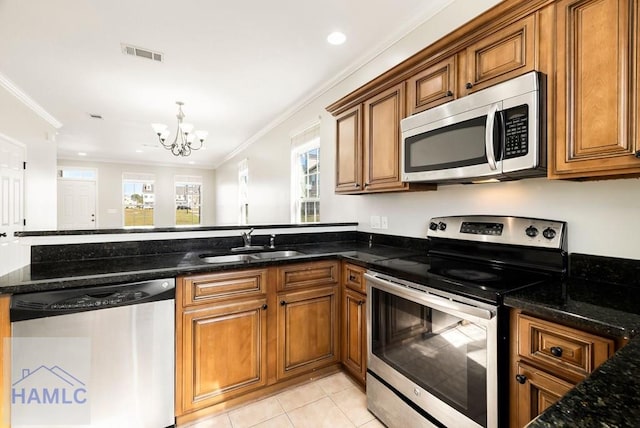 kitchen featuring visible vents, a sink, appliances with stainless steel finishes, crown molding, and brown cabinets