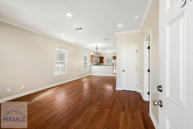 unfurnished living room with visible vents, dark wood-style floors, crown molding, baseboards, and a chandelier