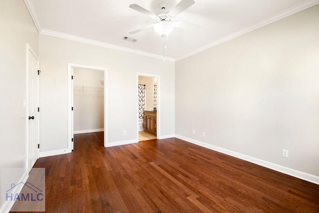 unfurnished bedroom featuring a spacious closet, baseboards, ornamental molding, wood finished floors, and a closet