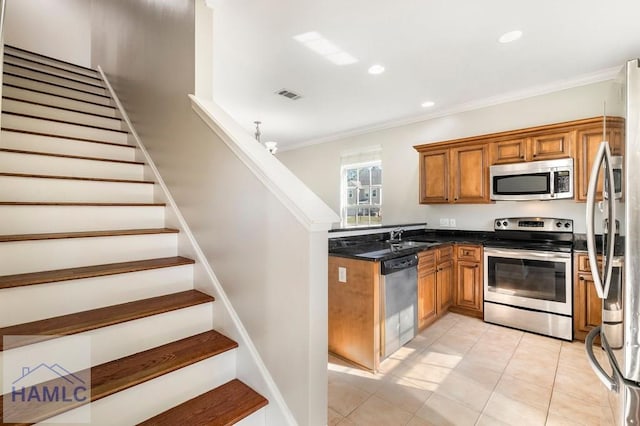 kitchen with brown cabinetry, visible vents, a sink, ornamental molding, and stainless steel appliances