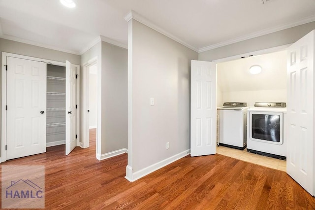 laundry area with washer and dryer, light wood-style floors, ornamental molding, and laundry area