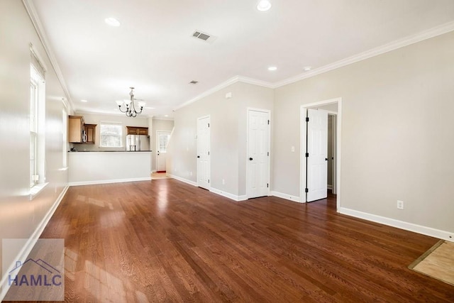 unfurnished living room featuring dark wood finished floors, a chandelier, baseboards, and ornamental molding