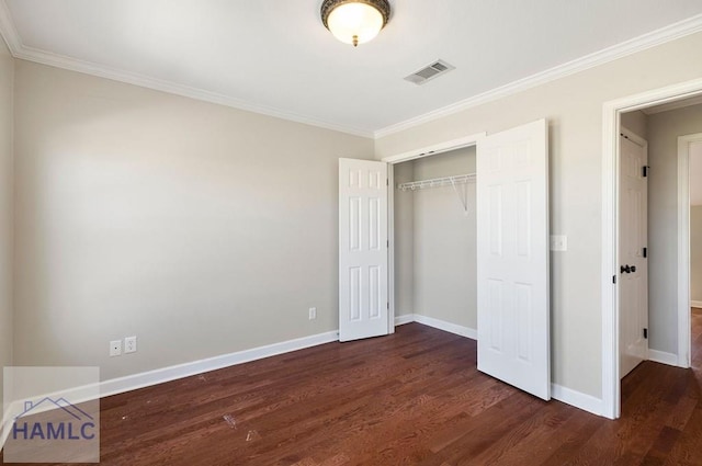 unfurnished bedroom with visible vents, dark wood-type flooring, ornamental molding, a closet, and baseboards