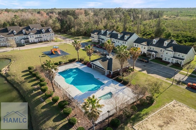 drone / aerial view featuring a residential view and a view of trees