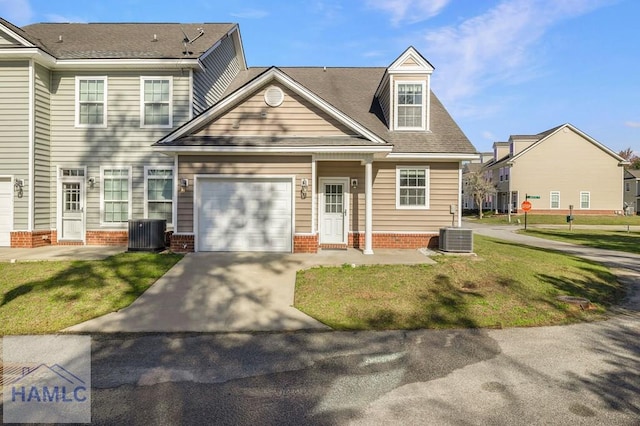 view of front facade with a front lawn, central AC, brick siding, and driveway