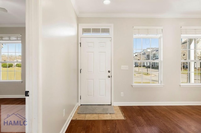 entryway featuring wood finished floors, baseboards, and ornamental molding