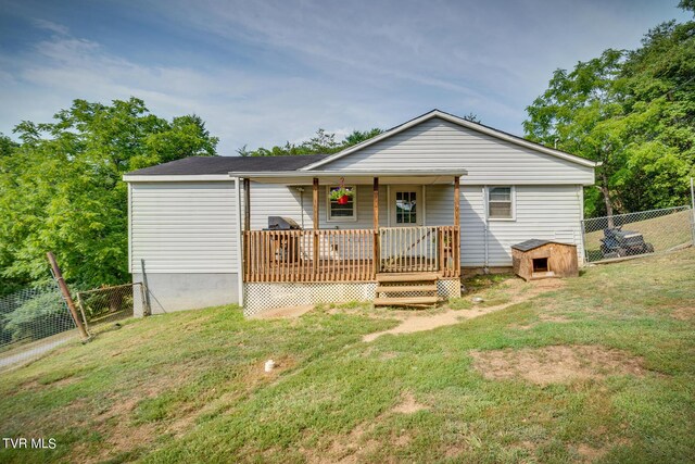 single story home with a wooden deck and a front yard