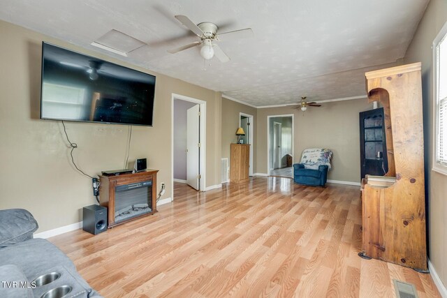 living area with light wood-style flooring, attic access, visible vents, and baseboards