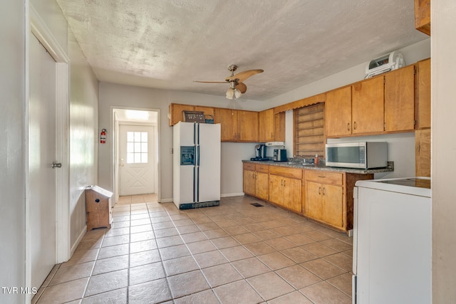 kitchen featuring washer / clothes dryer, light tile patterned flooring, ceiling fan, and white fridge with ice dispenser