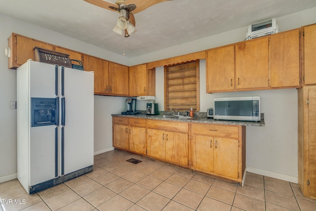 kitchen featuring sink, white refrigerator with ice dispenser, ceiling fan, and light tile patterned floors