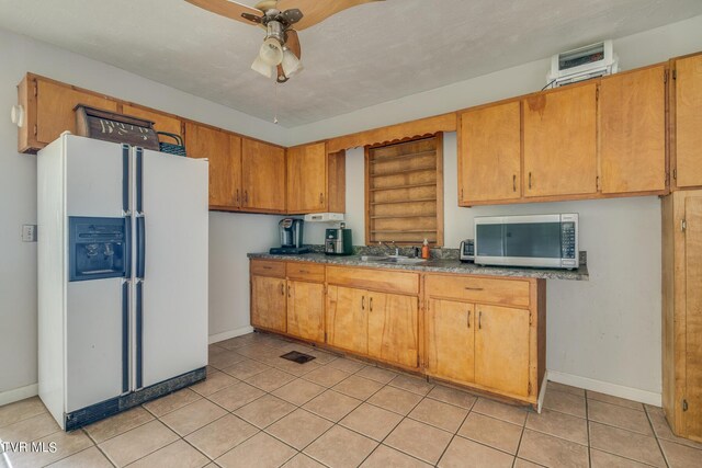 kitchen featuring ceiling fan, light tile patterned floors, a sink, white fridge with ice dispenser, and stainless steel microwave