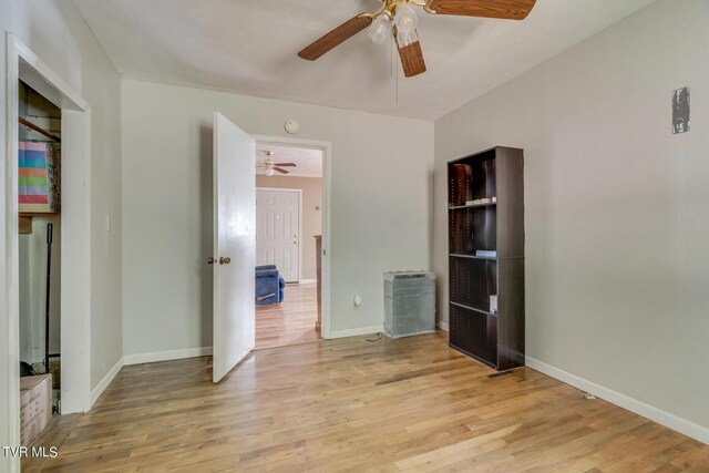 unfurnished bedroom featuring a ceiling fan, baseboards, and light wood finished floors