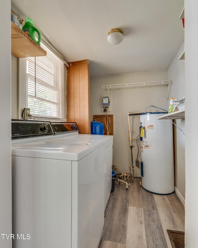 laundry room featuring light hardwood / wood-style floors, washer and clothes dryer, and water heater