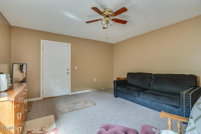 carpeted living area featuring a ceiling fan and baseboards