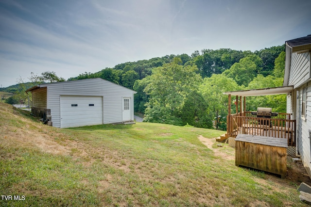 view of yard with a deck, an outdoor structure, and a garage