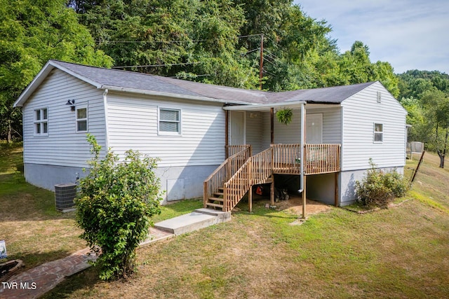 view of front of home with stairs, a front yard, and cooling unit