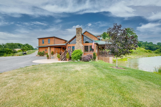 log cabin featuring a water view and a front lawn