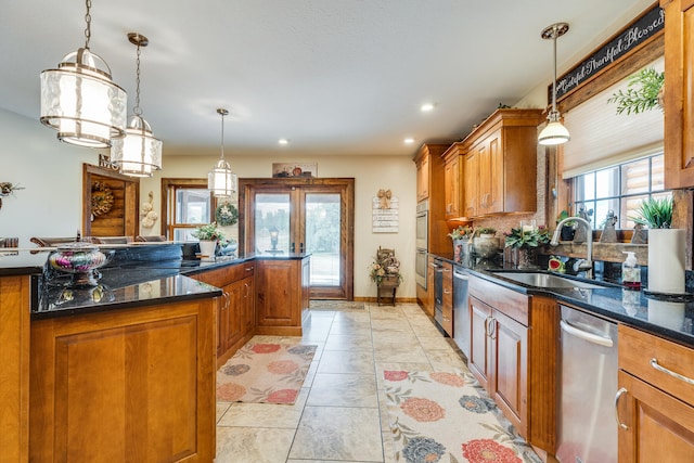 kitchen featuring stainless steel dishwasher, pendant lighting, and plenty of natural light