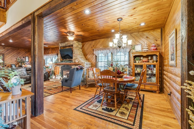 dining area featuring wood walls, wooden ceiling, and light wood-type flooring