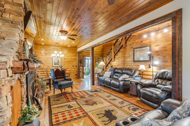 living room featuring wood ceiling, light hardwood / wood-style floors, ceiling fan with notable chandelier, and log walls