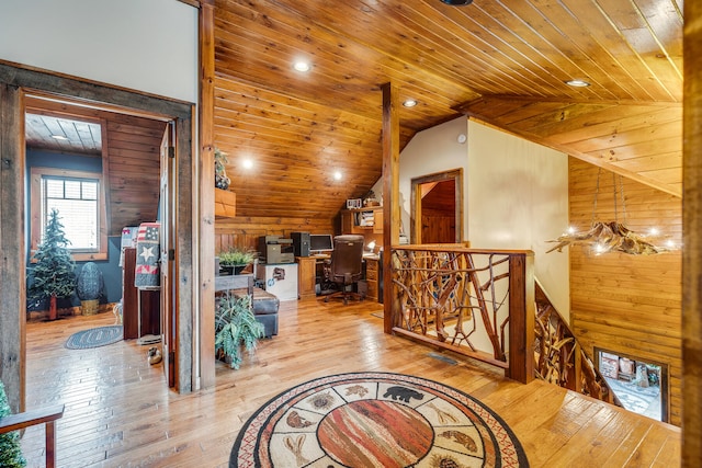 interior space with wood walls, wooden ceiling, vaulted ceiling, and light hardwood / wood-style flooring