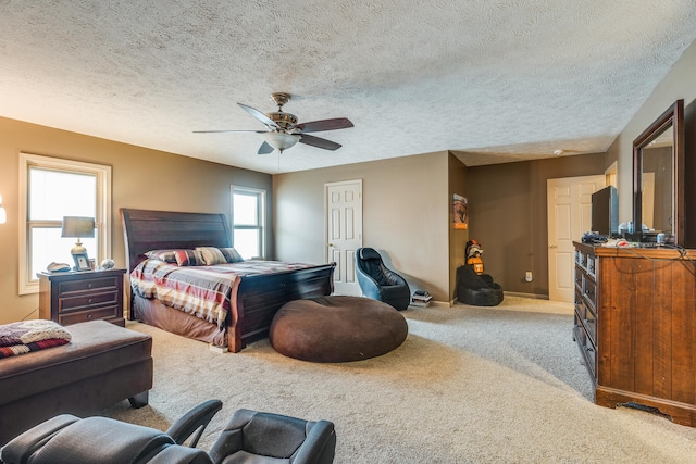 bedroom featuring ceiling fan, a textured ceiling, and carpet