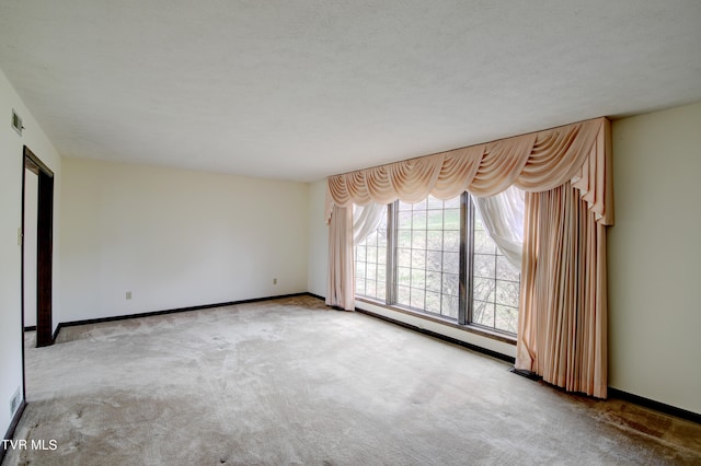 carpeted empty room with a textured ceiling