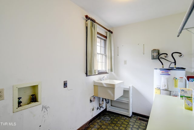 clothes washing area with electric dryer hookup, hookup for a washing machine, electric water heater, dark tile floors, and sink