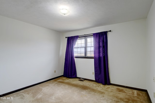 carpeted spare room with a textured ceiling