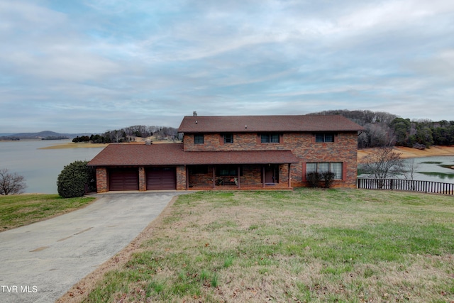 view of front facade featuring a front yard, a water view, and a garage