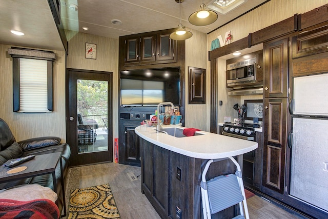 kitchen featuring white fridge, sink, dark brown cabinetry, stainless steel microwave, and dark hardwood / wood-style flooring