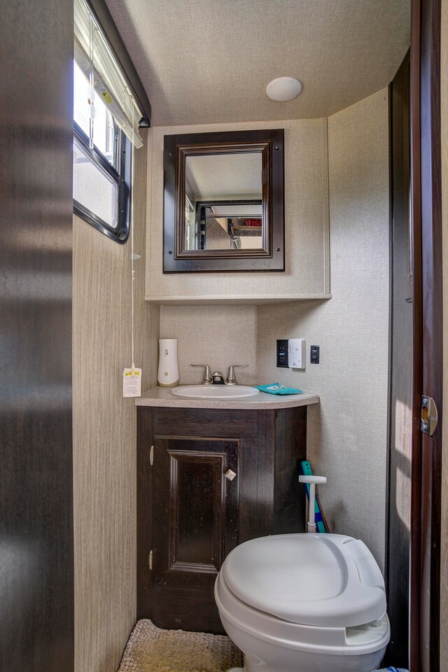 bathroom featuring vanity, a textured ceiling, and toilet