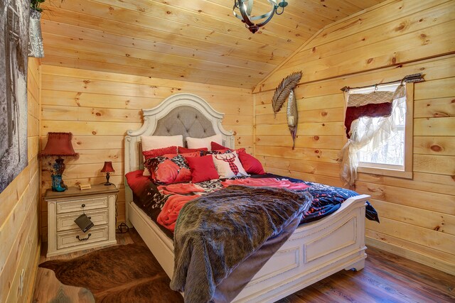 bedroom with wooden walls, vaulted ceiling, wooden ceiling, and dark hardwood / wood-style flooring