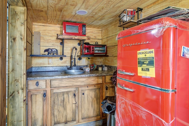 kitchen featuring wood walls, wooden ceiling, and sink