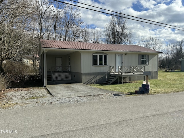 manufactured / mobile home with a carport and a front lawn