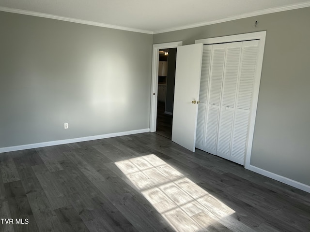 unfurnished bedroom featuring a closet, ornamental molding, and dark hardwood / wood-style floors