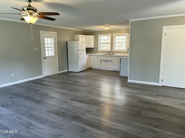 kitchen featuring sink, dark hardwood / wood-style floors, ornamental molding, white cabinets, and white fridge