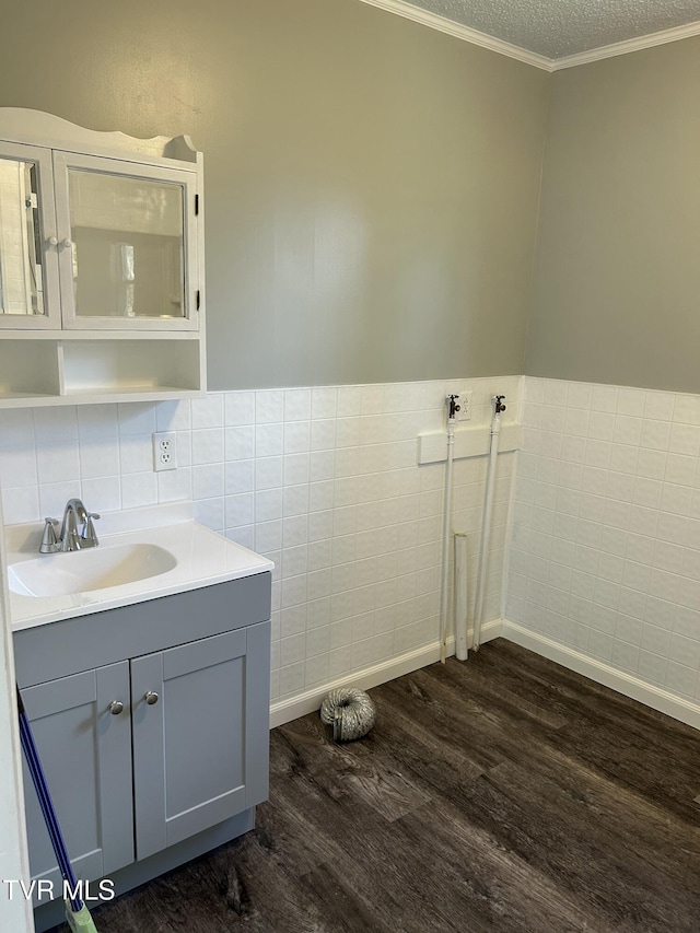 bathroom featuring crown molding, tile walls, hardwood / wood-style floors, vanity, and a textured ceiling