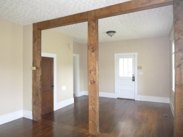 unfurnished room with dark hardwood / wood-style flooring and a textured ceiling