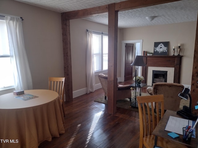 dining space with plenty of natural light, dark hardwood / wood-style floors, and a textured ceiling